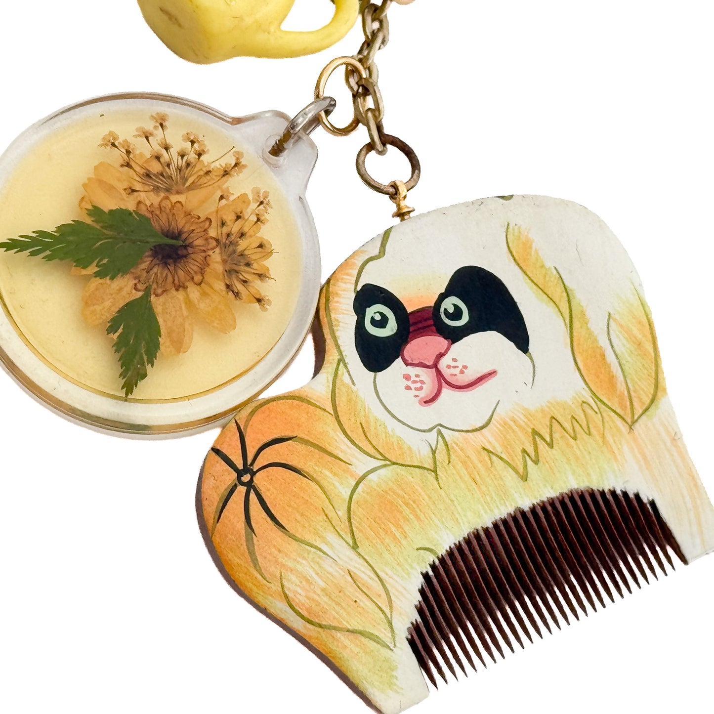 miki yamamoto「キーリング “Yellow Dog”」犬の絵が描かれた櫛、押し花、黄色い水差し、ヴィンテージの金属チャームなどを組み合わせた一点もののキーリング。